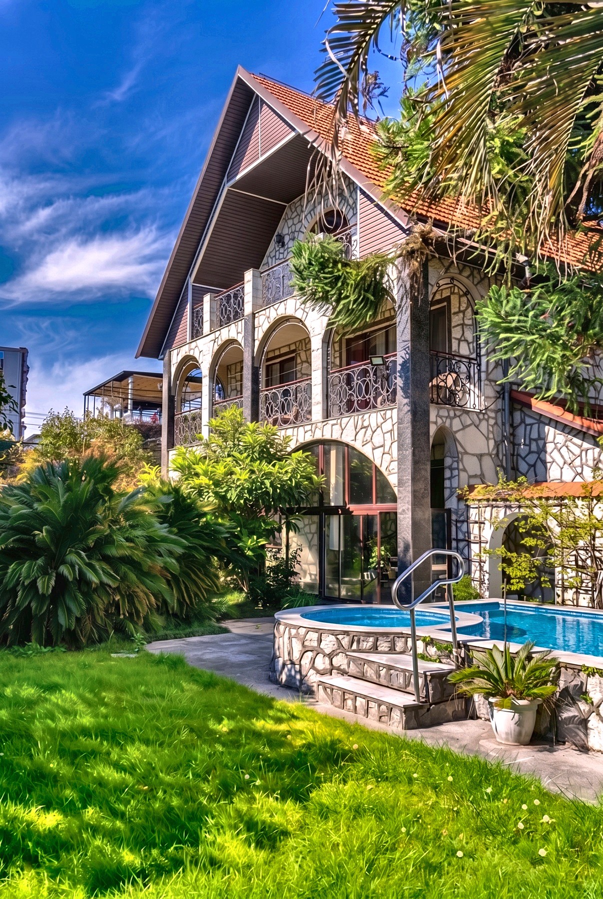 Villa Alexandria — каменный фасад с арками и коваными балконами